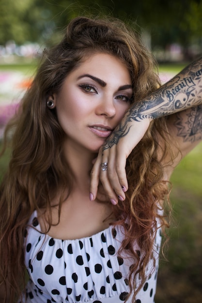 Premium Photo | Seductive young woman with curly wild hair and tatooes.