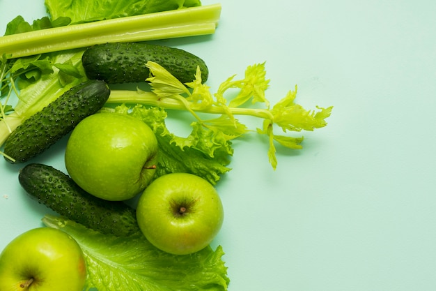 セレクティブフォーカス デトックス栄養 野菜や果物の緑の食事 青色の背景に天然物 プレミアム写真