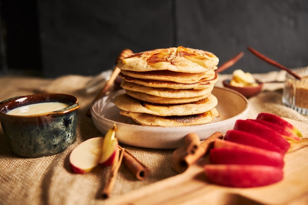 Selective focus shot of apple pancakes with apples and other ingredients on the table Free Photo