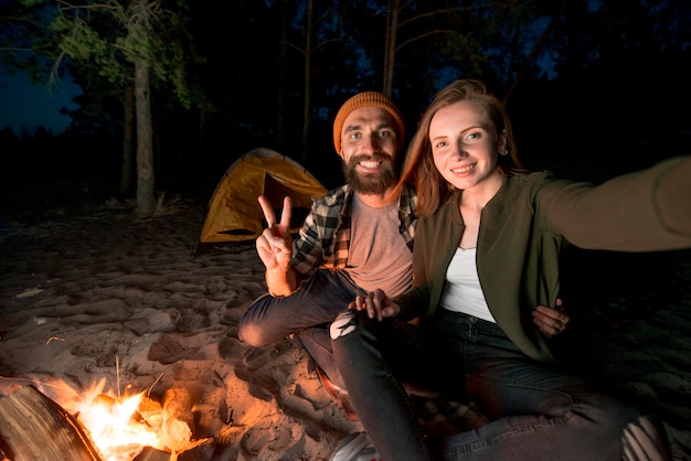 Selfie of couple camping at night by campfire Free Photo