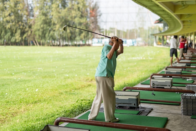 Senior Man Exercise Practicing His Golf Swing At Golf