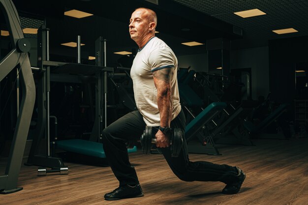 Premium Photo | Senior man in his fifties lifting weights in a gym