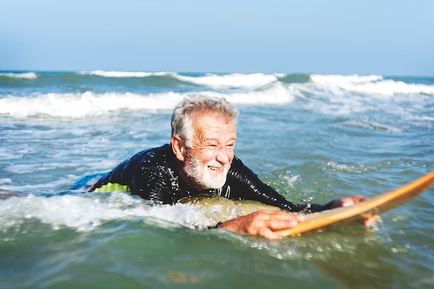 Premium Photo A Senior Man On A Surfboard