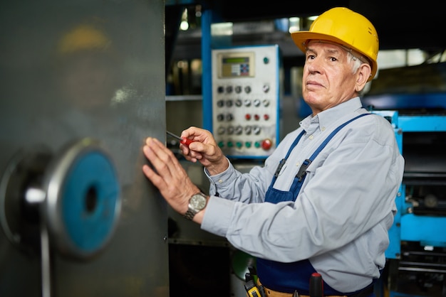 Premium Photo | Senior mechanic repairing machines