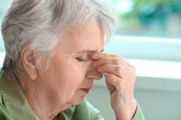 Senior woman suffering from headache at home Premium Photo