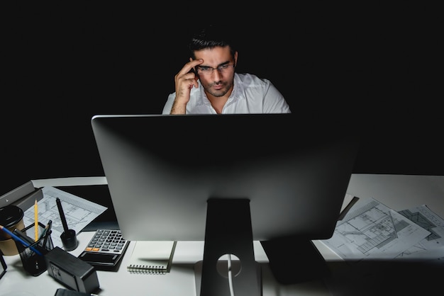 Serious asian businessman working late at night in the office Premium Photo