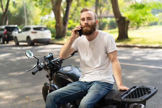 Serious biker calling roadside assistance Free Photo