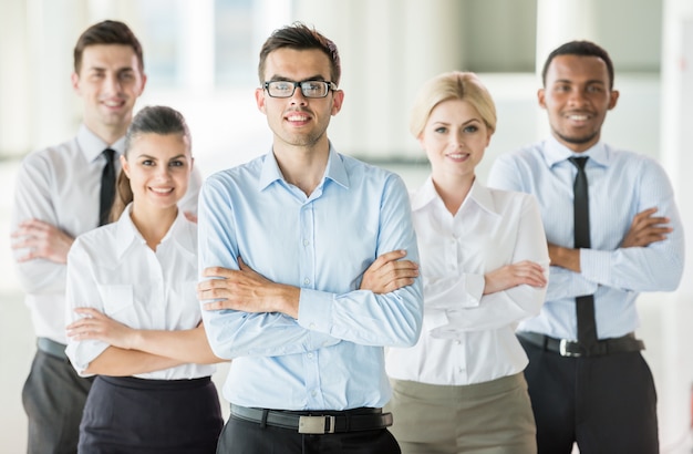 Premium Photo | Serious boss with arms folded standing in a modern office.