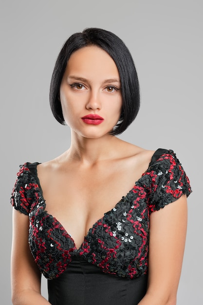 Serious Lady With Short Dark Hair And Red Lips Posing In Studio