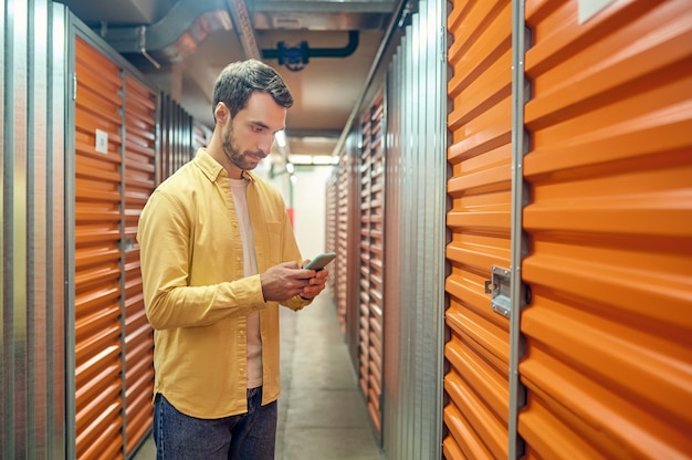 Premium Photo | Serious man looking at smartphone in basement