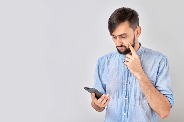 Premium Photo | Serious pensive face man holding mobile phone and ...