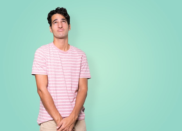 Premium Photo | Serious young man looking against background