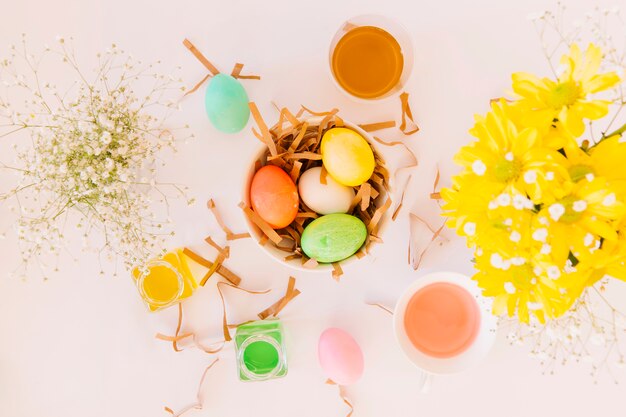 Free Photo | Set of bright easter eggs in bowl between fresh flowers ...