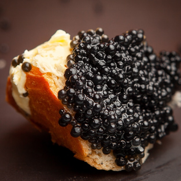 Free Photo | Set of butter and black caviar on a bread on dark ...