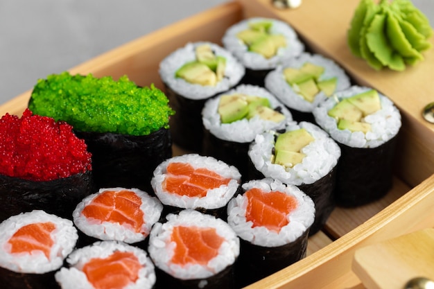 Premium Photo | Set of maki sushi on wooden boat tray