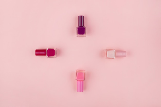 Premium Photo | Set of nail polishes and flowers on a pink wall. beauty ...