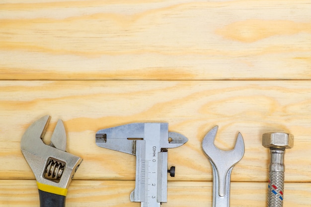 Premium Photo | Set tools and water hose for plumbers on wooden boards ...