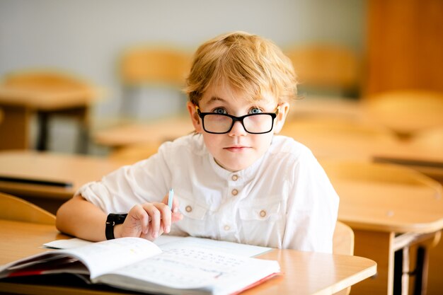 Premium Photo | Seven years old child with glasses writing his homework ...