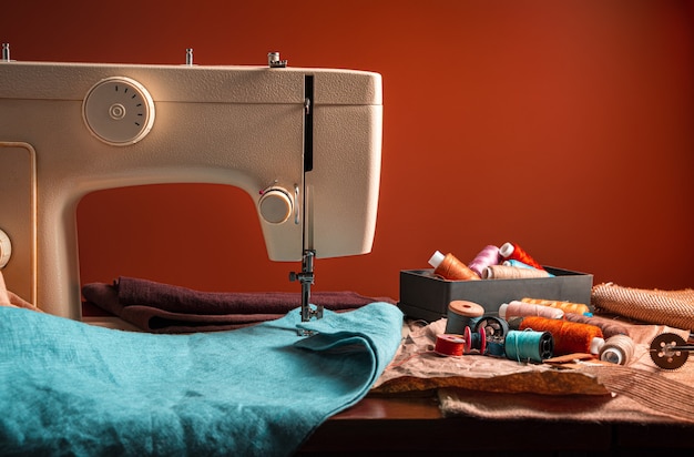 Premium Photo | Sewing machine and sewing accessories on a brown ...