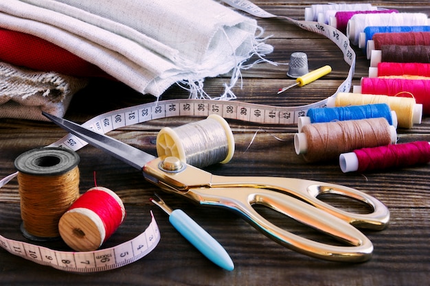 Premium Photo | Sewing tools, multi-coloured fabric and threads on a ...