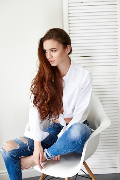 Premium Photo | Sexy beautiful girl in jeans white shirt sitting