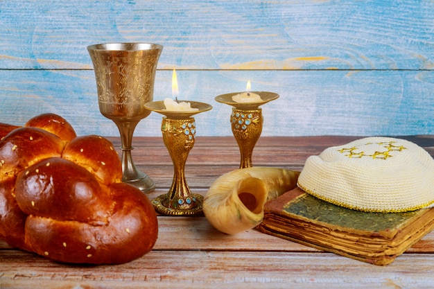 Shabbat challah bread, shabbat wine and candles on the table Premium Photo