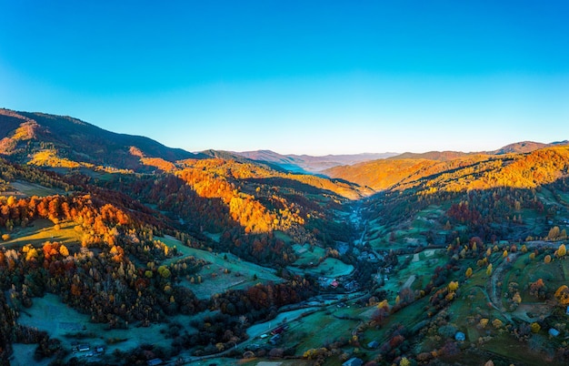 Premium Photo | Shaded mountain valley with houses and forests at sunset