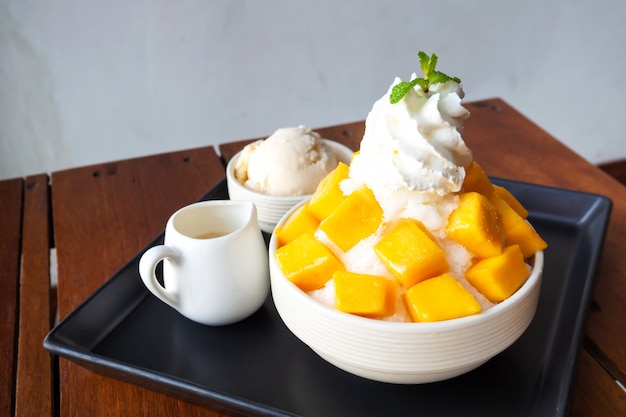 Shaved ice dessert with mango sliced. served with vanilla ice cream and whipped cream. Premium Photo