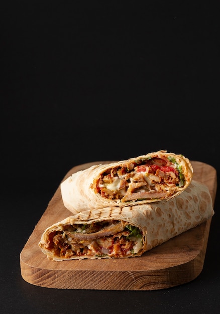 Shawarma, roll in lavash , grilled meat, with vegetables, sandwich Premium Photo