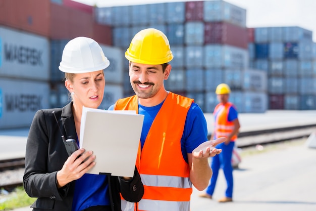 Premium Photo | Shipping company workers in front of containers