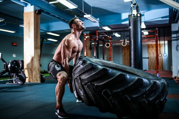 Shirtless man flipping heavy tire Premium Photo