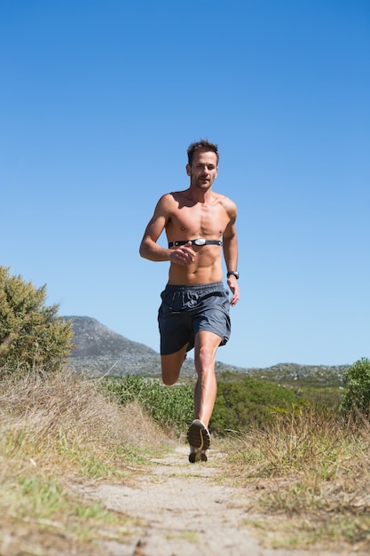 Premium Photo | Shirtless man jogging with heart rate monitor around chest