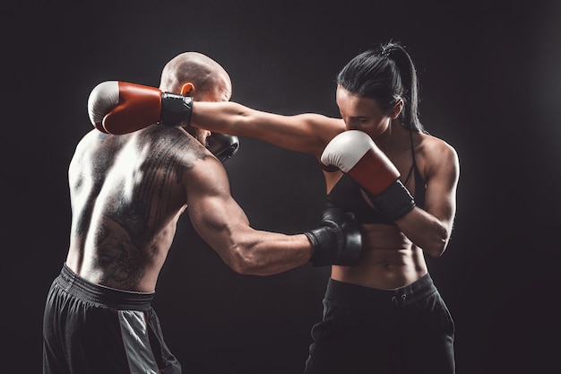 Premium Photo | Shirtless woman exercising with trainer at boxing and ...