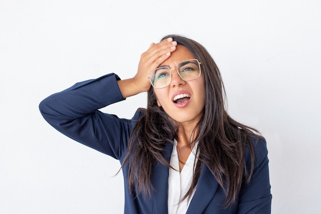Shocked businesswoman with hand on forehead Free Photo