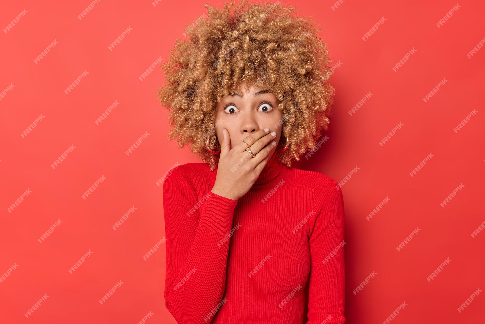 Free Photo Shocked Curly Haired Woman Gasps From Wonder Covers Mouth