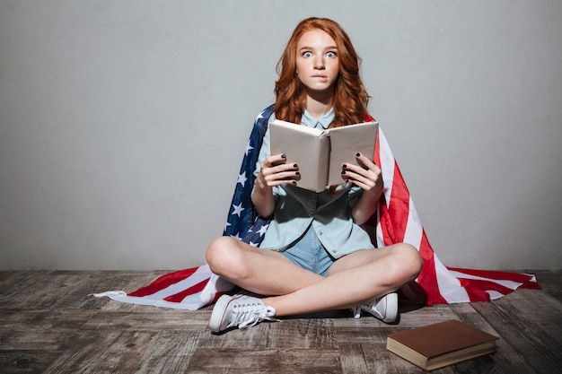 Free Photo Shocked Redhead Young Lady Reading Book Wearing Usa Flag 