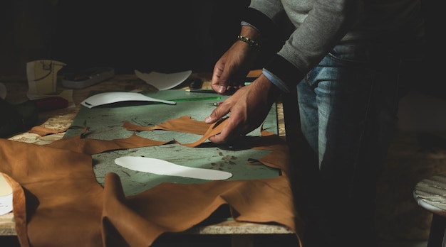 Shoemaker cutting leather Premium Photo