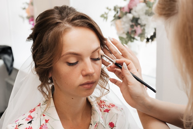 Premium Photo Shooting In A Beauty Salon Makeup Artist Applies Makeup To A Young Beautiful