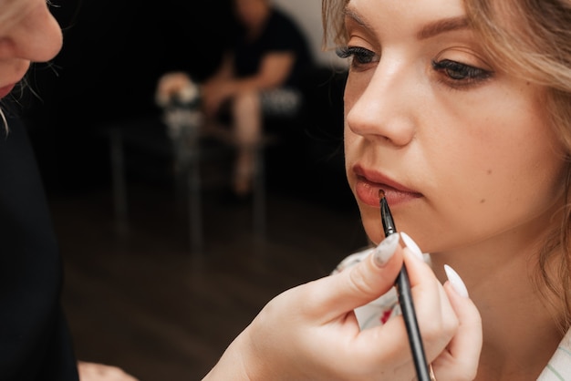 Premium Photo Shooting In A Beauty Salon Makeup Artist Applies Makeup To A Young Beautiful