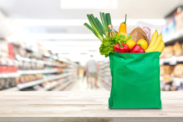 Shopping bag with food and groceries on the table in supermarket ...