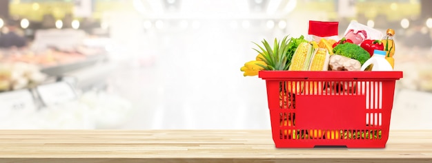 Shopping basket full of food and groceries on the table in supermarket