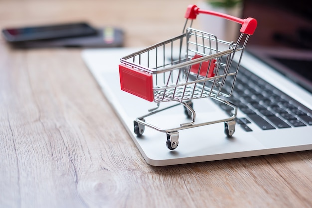 Premium Photo | Shopping cart on laptop at home office