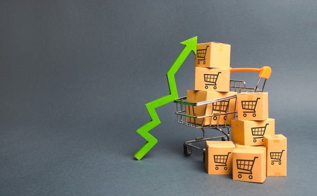 Shopping cart with cardboard boxes with a pattern of trading carts and a green up arrow Premium Photo