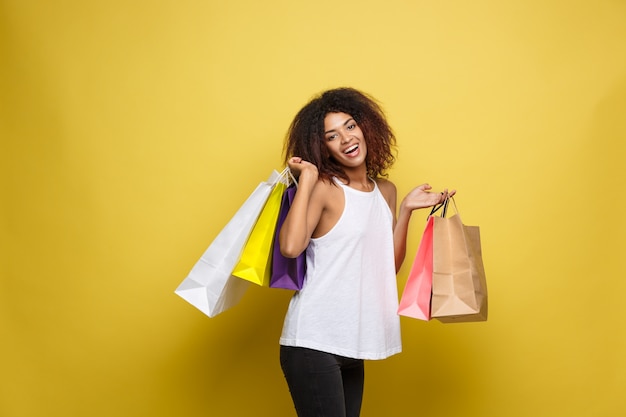 Shopping Concept Close Up Portrait Young Beautiful Attractive African Woman Smiling And Joyful With Colorful Shopping Bag Yellow Pastel Wall Background Copy Space Free Picture On Freepik