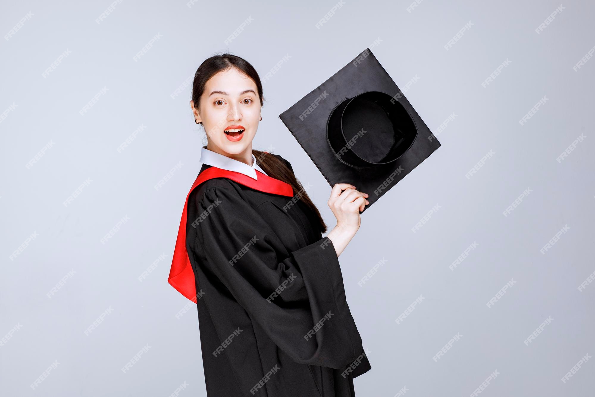 Free Photo | Shot of young student in gown showing her graduation cap ...
