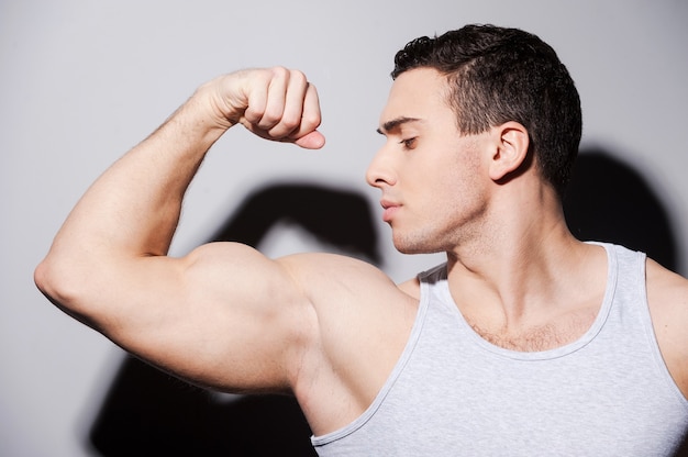 Premium Photo | Showing his perfect bicep. handsome young muscular man ...