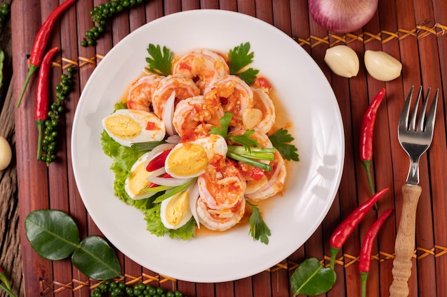 Shrimp salad with boiled egg lettuce and chopped scallions in a white plate Free Photo