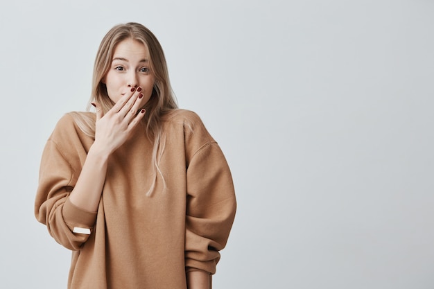 恥ずかしがり屋の若い女性 恥ずかしがり屋や恥ずかしがり屋のブロンドの髪を持つクローズアップの肖像女性 無料の写真