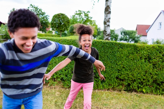 Siblings playing in garden Premium Photo