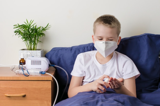 Premium Photo | Sick boy in medical protective mask using hand sanitizer